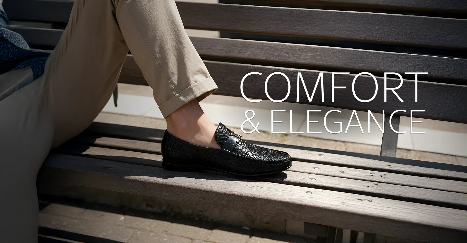 Person wearing black loafers on a wooden bench with 'COMFORT & ELEGANCE' text.